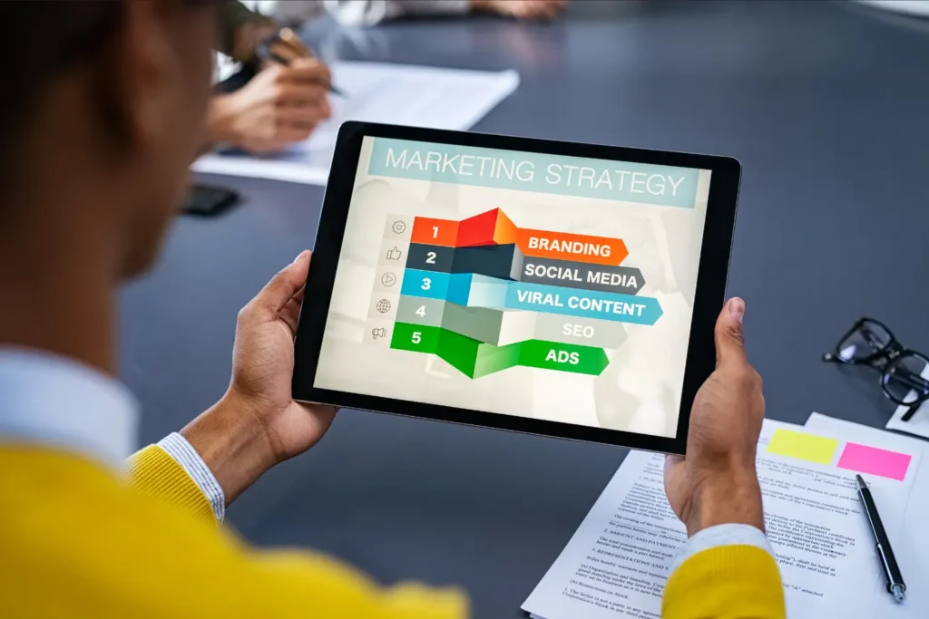 a man looking at marketing strategies on his tablet - Digitech